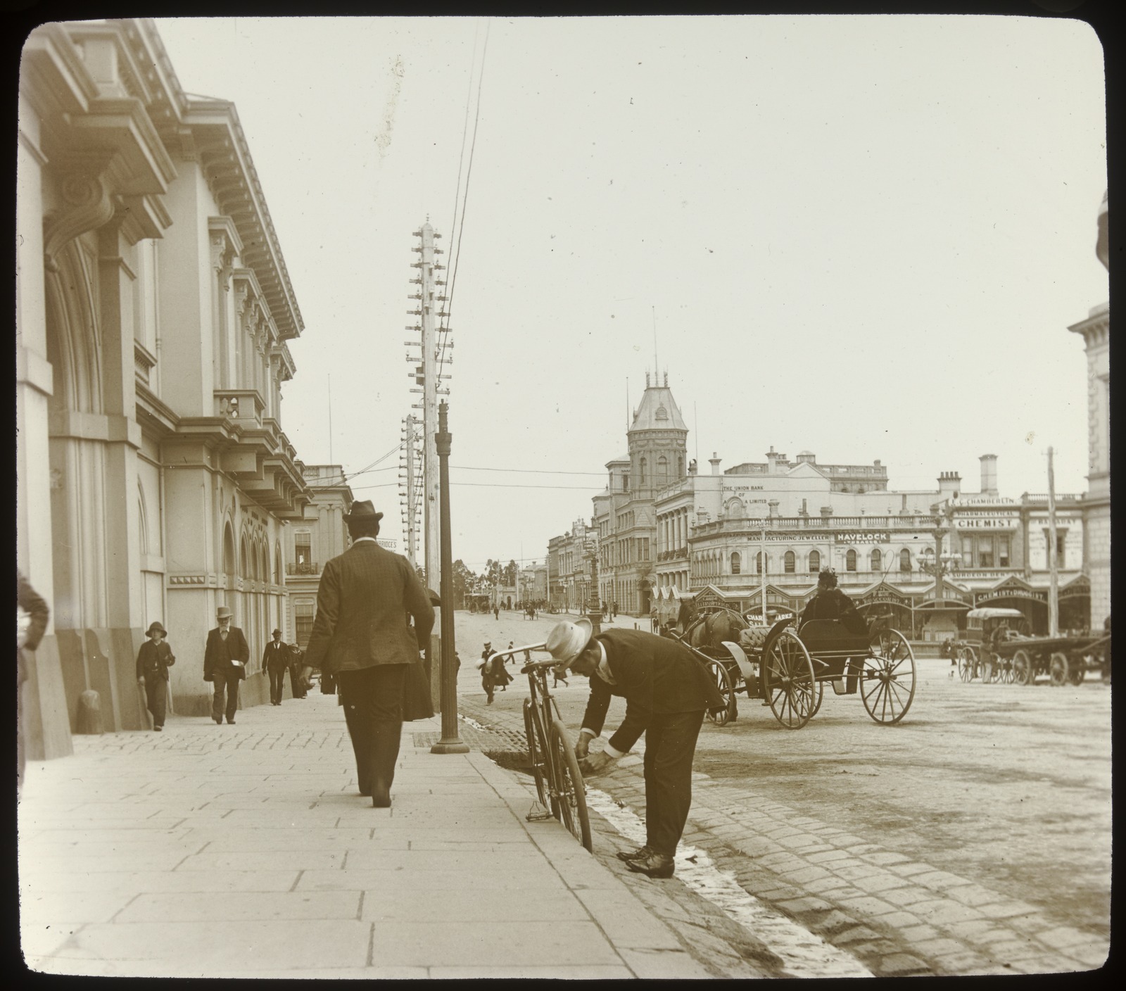 Sepia tone photograph depicting Lydiard Street, Ballarat. Pedestrians, man leaning next to bicycle, horse and buggy