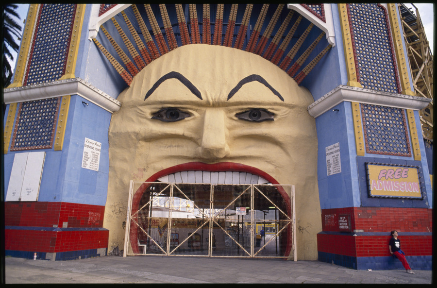 Luna Park Mr Moon face entrance with gates closed; boy leaning against tiled wall