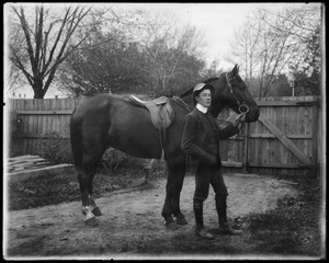 Man standing beside a saddled horse